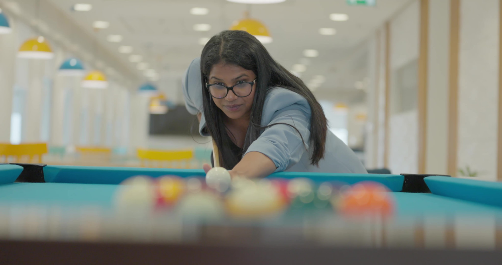 Still image of Informa employee playing pool from b-roll video footage for Life@Informa campaign as Employer brand page cover