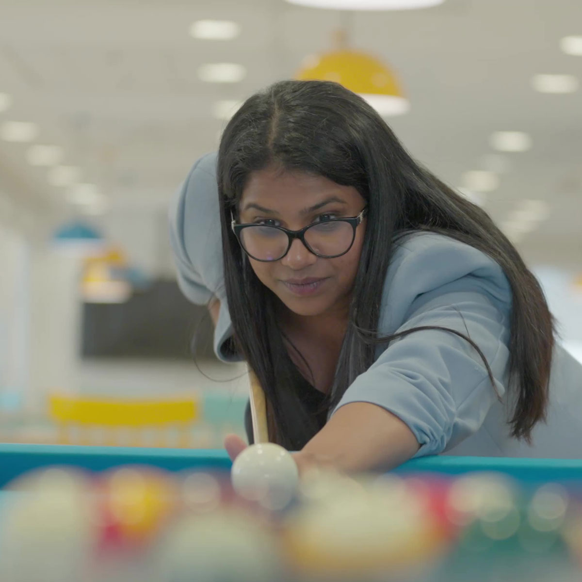 Life@Informa employer brand campaign for Informa with employee playing pool